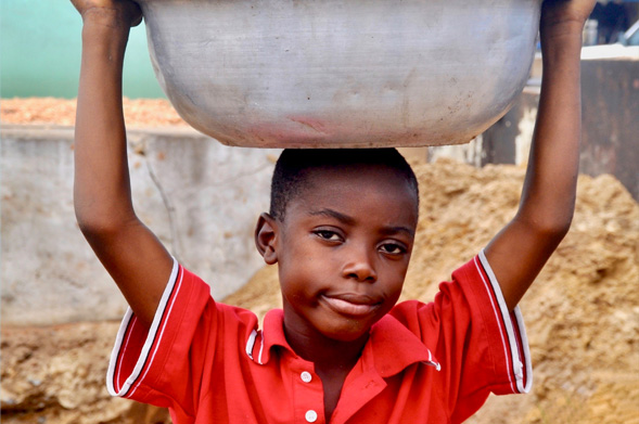 African boy holding a vessel on his head