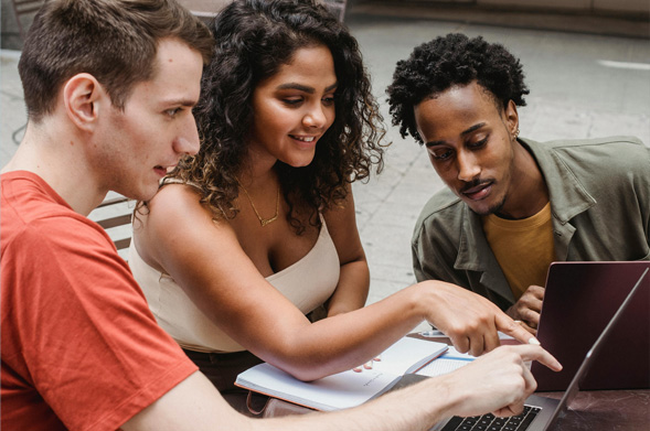 Three young people looking at a laptop screen