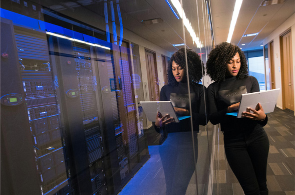 Woman working on a laptop in a server room
